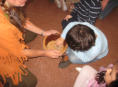 Everyone takes turns to mash cornmeal in the Native American way